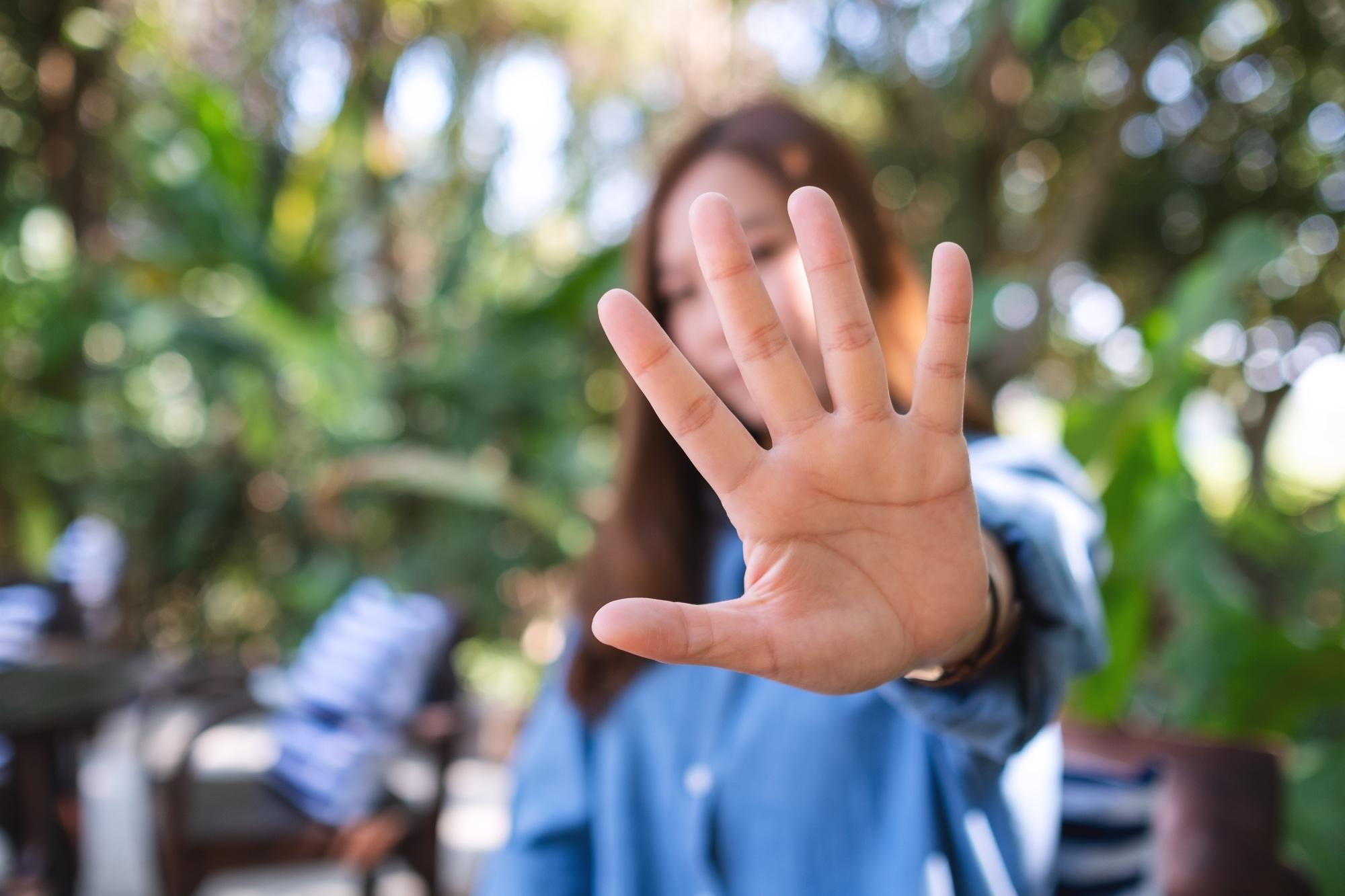 A young woman outstretched hand and showing stop hand sign