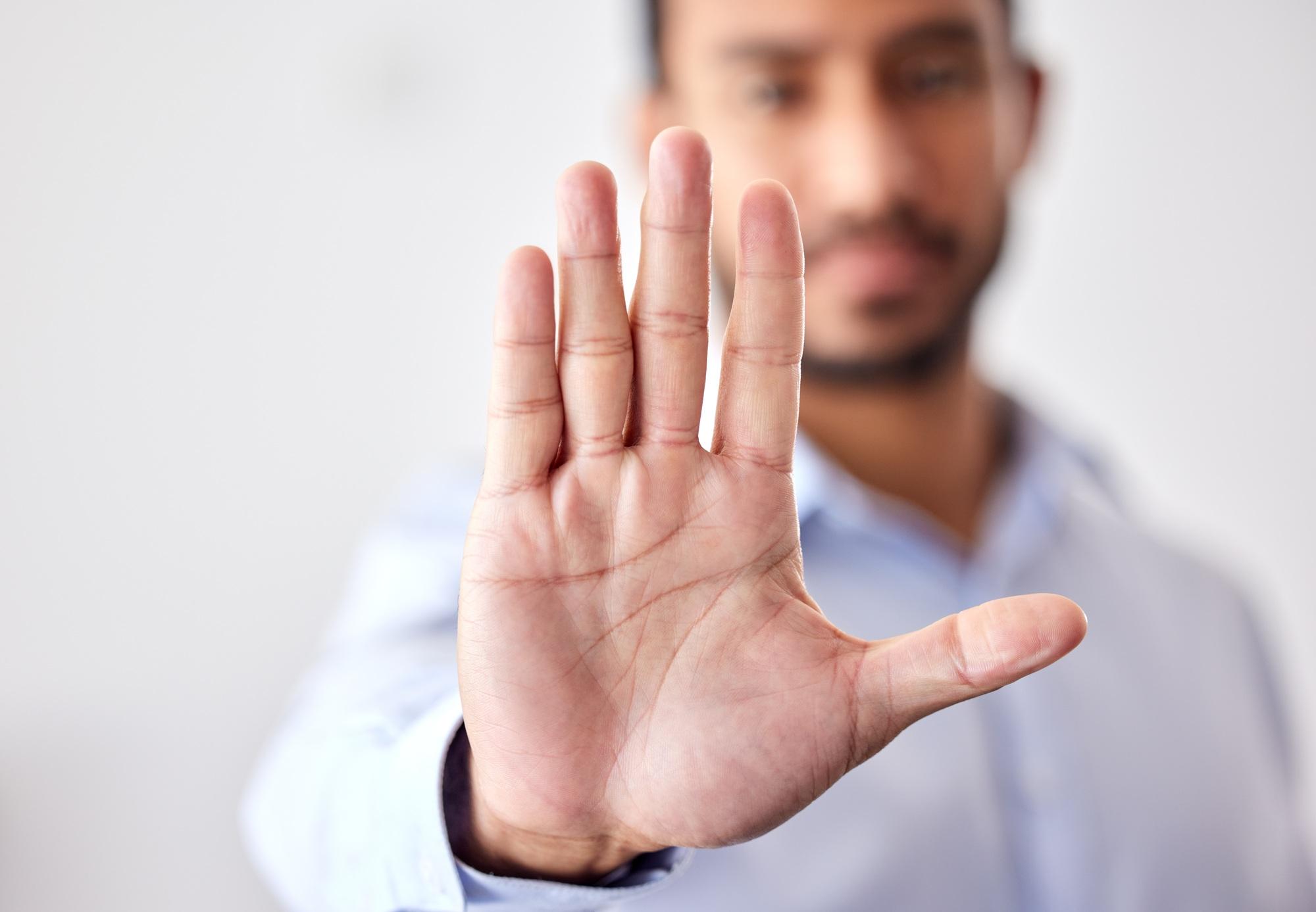 Closeup of the hand of a business man showing stop, saying no or not accepting a deal in an office