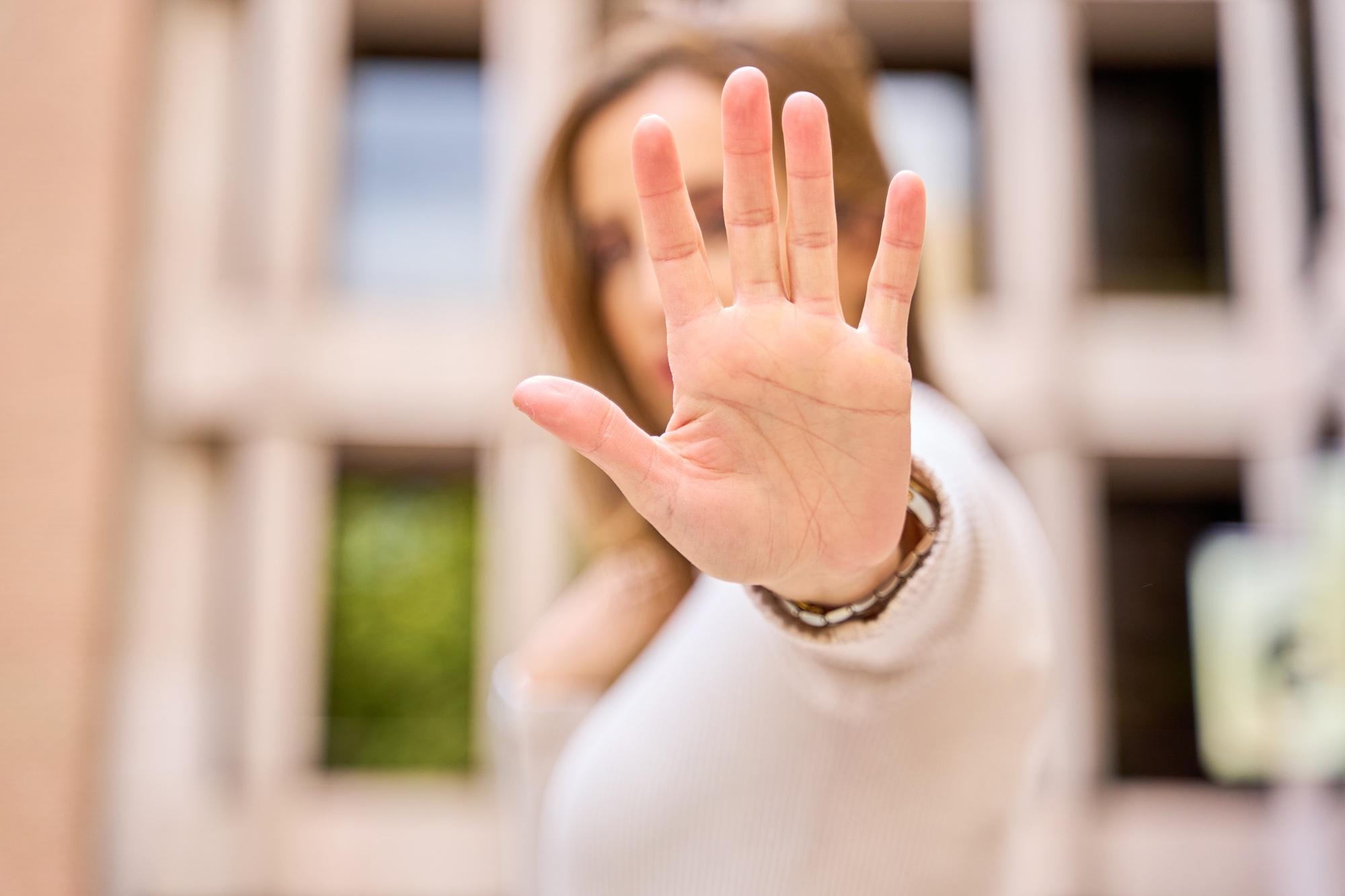 Woman making a stop hand gesture with focus on hand
